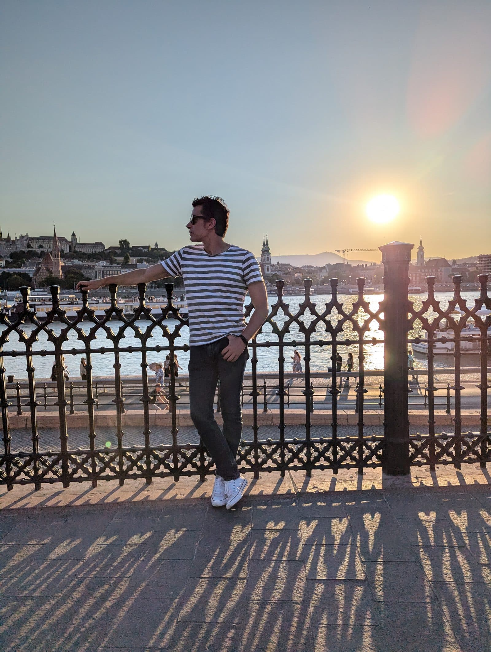 Diego Fresno on the Chain Bridge in Budapest at sunset, with the Hungarian Parliament building across the Danube