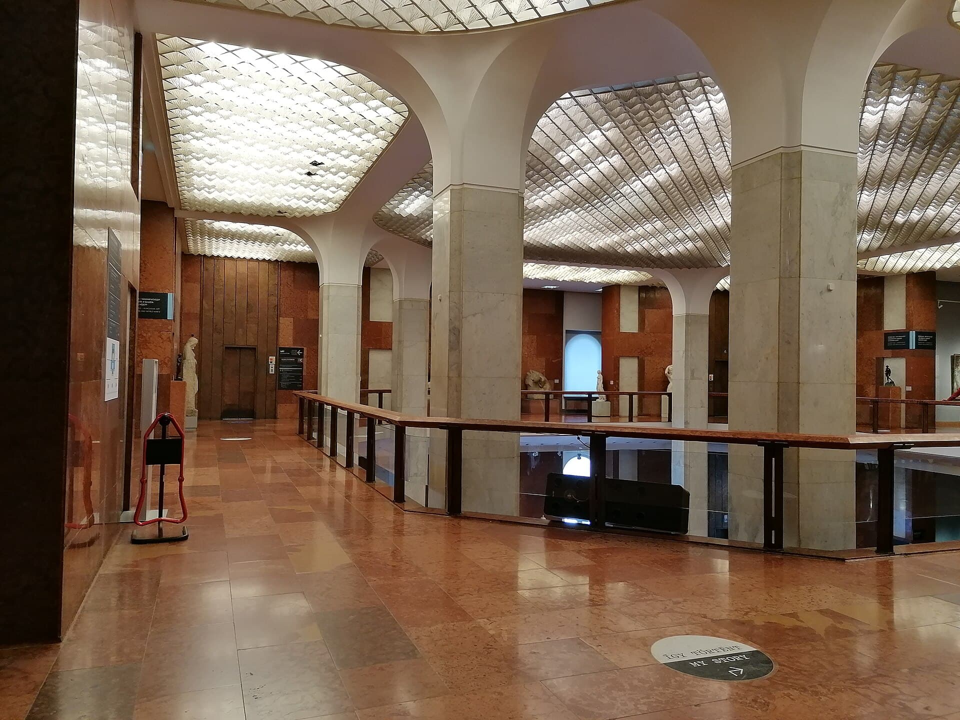 A gallery inside the Hungarian National Gallery in Buda Castle, with paintings hung on pale walls and daylight from a high window